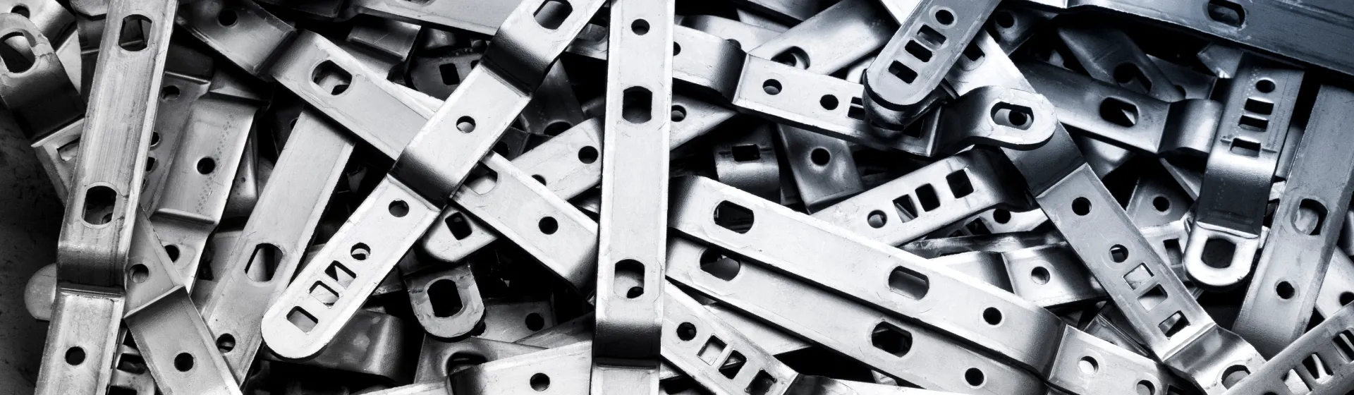 Sheet metal brackets with rectangular holes and slots produced by metal shearing
