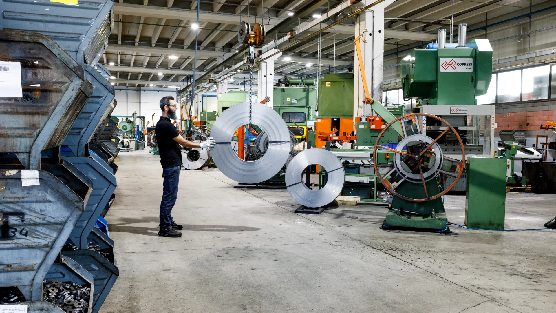 Reparto stampaggio di Sifral, azienda di lavorazione metalli, con coils di lamiera e presse